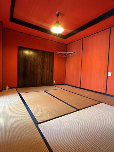 an empty room with red walls and a door at Airport Osaka in Kaizuka