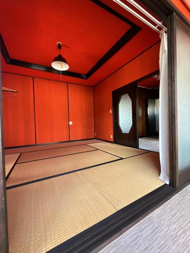 an empty room with red walls and a large room with at Airport Osaka in Kaizuka