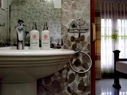 ein Badezimmer mit zwei Flaschen auf einem Waschbecken in der Unterkunft Tantra Ella Lodge in Ella