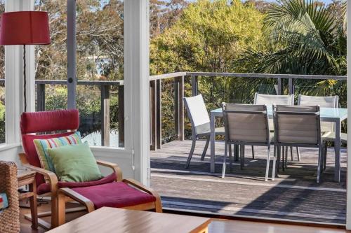 a room with a porch with chairs and a table at Blue on Collins in Merimbula