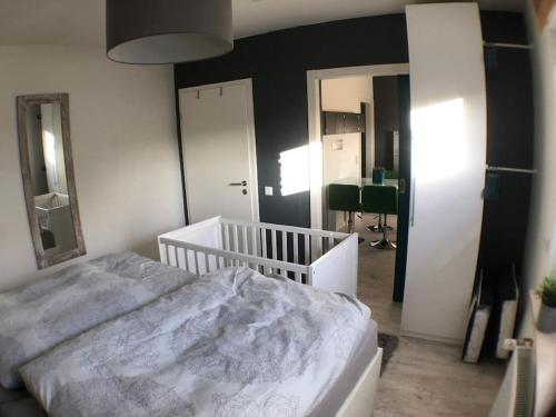 um quarto com uma cama branca e um espelho em Ferienwohnung Zum Wenning mit Garten in Stadtlohn em Stadtlohn