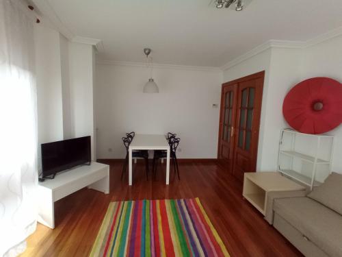 uma sala de estar com uma mesa e um sofá em Apartment with parking "Hola Oviedo" em Oviedo