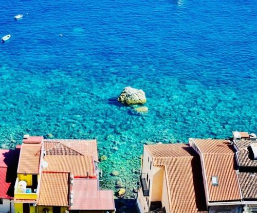 an aerial view of the ocean with a rock in the water at Brezza Marina in Scilla