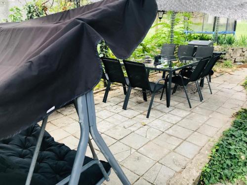 an umbrella on a patio with a table and chairs at Вила ОмниЯ in Chernomorets