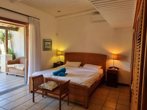 - une chambre avec un lit, une chaise et une terrasse couverte dans l'établissement Shanti Ghar Guest House, à Tamarin