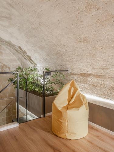 a yellow bean bag sitting on the floor next to a plant at Hydria Rooms in Matera
