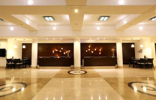 a lobby with tables and chairs in a building at Greenpark Hyderabad in Hyderabad