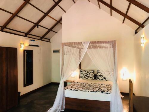 - une chambre avec un lit et une moustiquaire dans l'établissement The Countryside Udawalawe, à Uda Walawe
