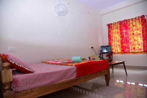 a bedroom with a bed and a table and a curtain at Dharinidhama Homestay in SanivÄrsante