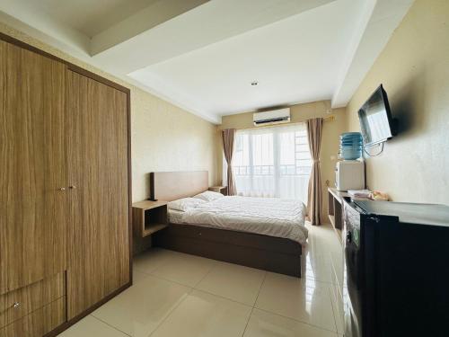 ein kleines Schlafzimmer mit einem Bett und einem Fenster in der Unterkunft Skyview Premier Suites Hozby in Sunggal