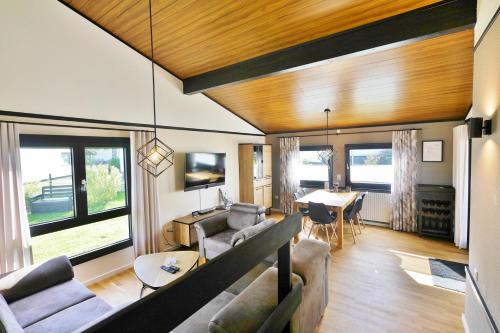 una sala de estar con un sofá y una mesa en Ferienhaus Diemelquelle - mit eingezäuntem Garten, en Willingen