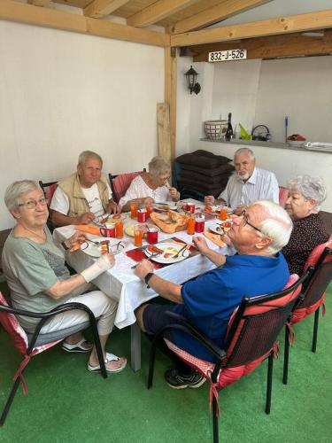 a group of people sitting around a table eating food at Guest House Nana in Mostar