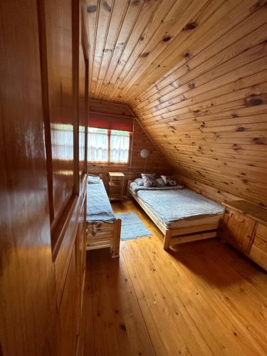 a room with two beds in a log cabin at Urocza chata z sauną w bieszczadzkim Parku Krajobrazowym in Bukowiec