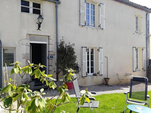 una casa con un patio con sillas y un edificio en le gîte du fou logement 8 pers 13mn puy du fou en Saint-Amand-sur-Sèvre