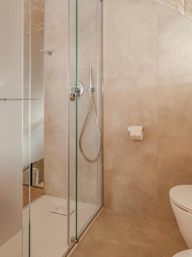 a shower with a glass door in a bathroom at Hydria Rooms in Matera