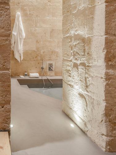 a bathroom with a concrete floor and a brick wall at Hydria Rooms in Matera