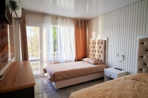 a bedroom with two beds and a large window at Blue Kokilia in Chilia Veche