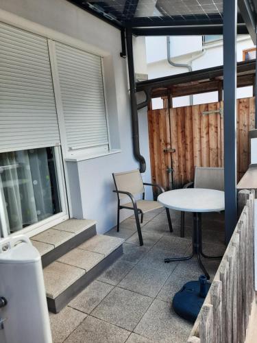 a patio with a table and chairs and windows at Ferienwohnungen Fryba in Bad Kleinkirchheim