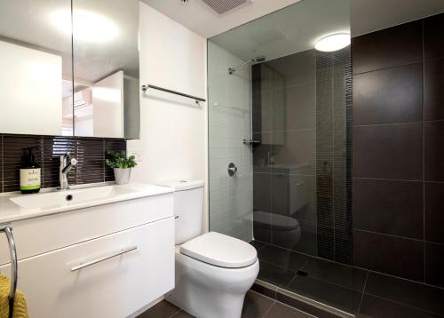 a bathroom with a white toilet and a shower at The Retreat Adelaide in Adelaide