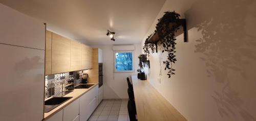 une cuisine avec des armoires blanches, une table et une fenêtre dans l'établissement TULIPE - Spacieux appart 105 m2 -3 Ch - PARIS EXPO - CACHAN, à Cachan