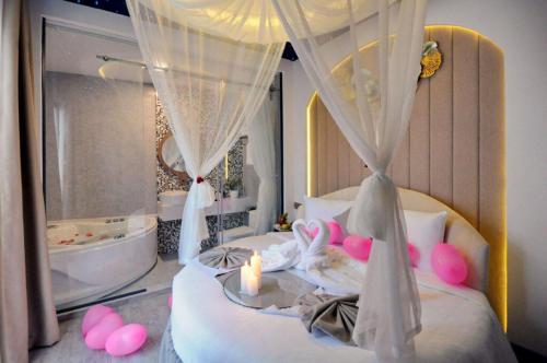 a bedroom with a bed with a candle and a tub at Ngọc Bích Hotel Da Nang in Da Nang