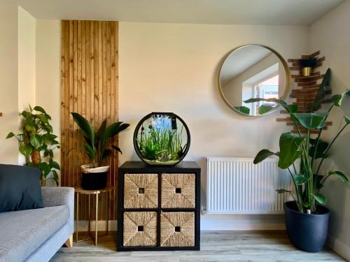 a living room with a mirror and plants at Single bedroom - Hampton Water, Peterborough in Peterborough