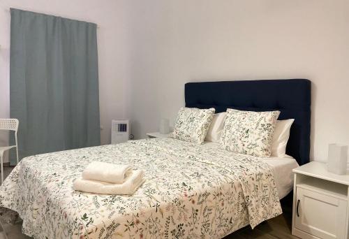 1 dormitorio con 1 cama grande y cabecero azul en Jandía Arena loft, en Morro del Jable