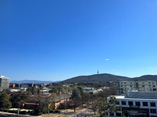 a view of a city with mountains in the background at Midnight Luxe 1BR Apartment in the heart of Braddon Views from L7 Pool Sauna Gym Secure Parking Wifi Wine in Canberra