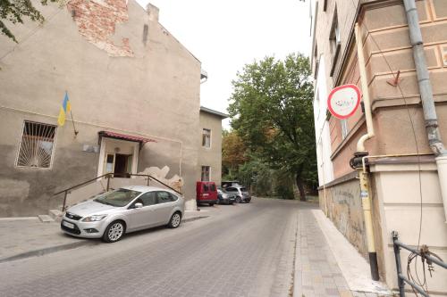 a car parked on a street next to a building at Cosmos in Ternopilʼ