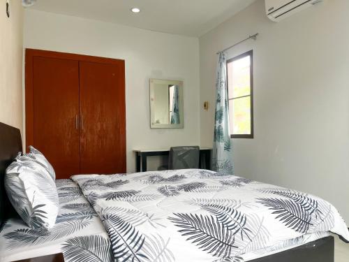 a bedroom with a bed with a black and white comforter at 2BR Maryam villa near Tesco & beach. in Bang Tao Beach