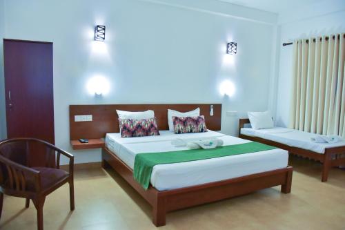 ein Schlafzimmer mit einem Bett und einem Stuhl darin in der Unterkunft Tropicara Resort in Sigiriya