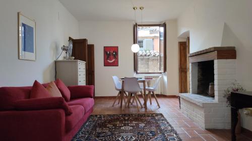 sala de estar con sofá rojo y chimenea en Numero 6, en Todi