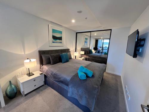 Un dormitorio con una cama con una almohada azul. en Midnight Luxe 1BR Executive Apartment in the heart of Braddon Views L7 Pool Sauna Gym Secure Parking Wifi Wine, en Canberra