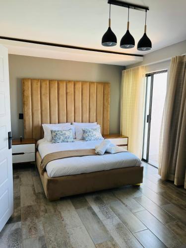 a bedroom with a large bed with a wooden headboard at Maison De luxe in Thohoyandou