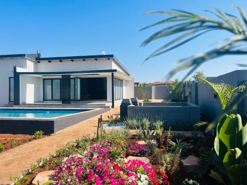 a house with a swimming pool and flowers at Maison De luxe in Thohoyandou