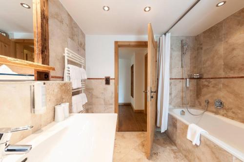 a bathroom with a large tub and a shower at Alpe Fleurie Residence in Villars-sur-Ollon