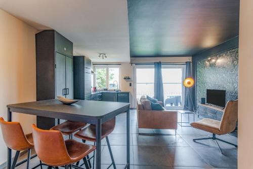 cocina y sala de estar con mesa y sillas en Les Figuiers - Appartement 2 Chambres avec Sauna à Andenne, en Andenne