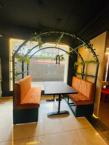 a table and two chairs in a room with an arch at Lee-Benz ARK HOTEL in Kumbakonam
