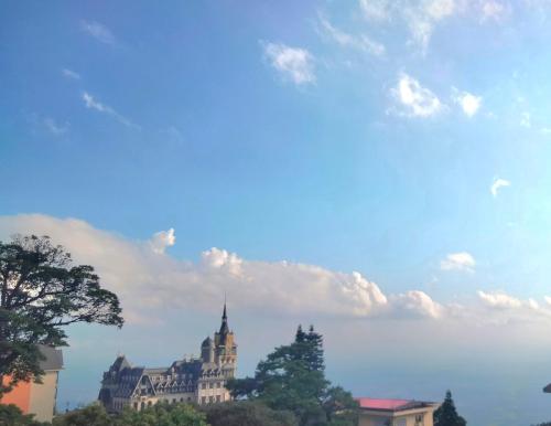 ein Gebäude auf einem Hügel mit wolkigem Himmel in der Unterkunft Đức An Hotel in Tam Ðảo