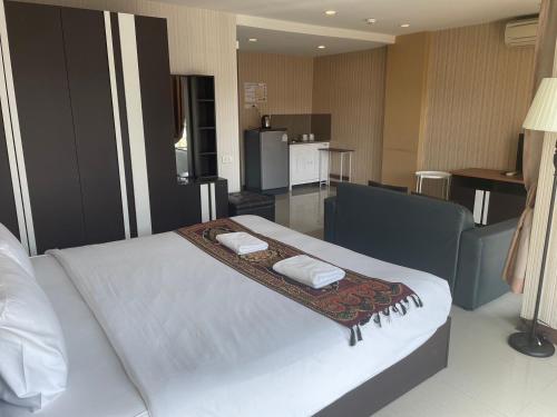 a bedroom with a bed with two towels on it at H2DO Hotel in Ban Khlong Sanam Phli