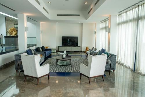 uma sala de estar com um sofá, uma mesa e cadeiras em Nurai Losin em Abu Dhabi