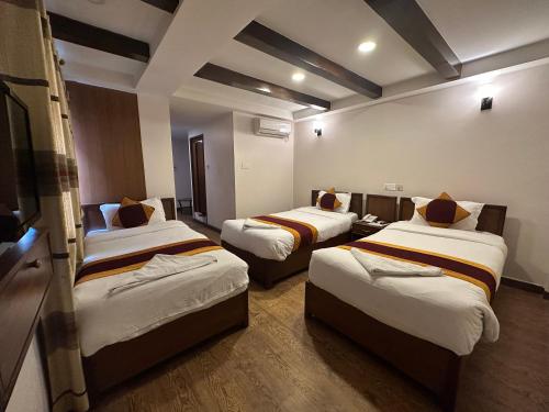 a room with three beds in a room at Hotel Everest Nepal in Kathmandu