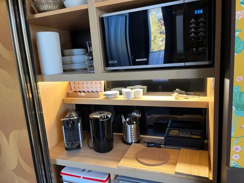 d'une cuisine équipée d'un four micro-ondes et d'ustensiles. dans l'établissement Un studio dans une villa balnéaire, à Saint-Michel-Chef-Chef