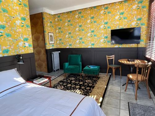 a bedroom with a bed and a tv and a table and chairs at Un studio dans une villa balnéaire in Saint-Michel-Chef-Chef