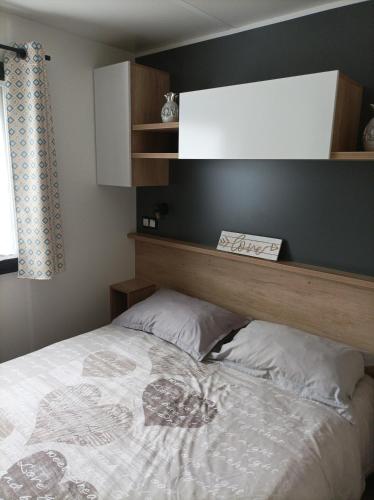 une chambre avec un lit avec une tête de lit en bois dans l'établissement Mobil home moderne neuf et ultra équipé de 6 à 8 couchages, à Canet