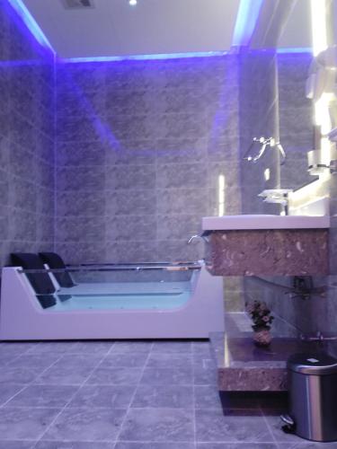 a bathroom with a tub and a sink at العلي للشقق المخدومة Alalihotel in Hafr Al Baten