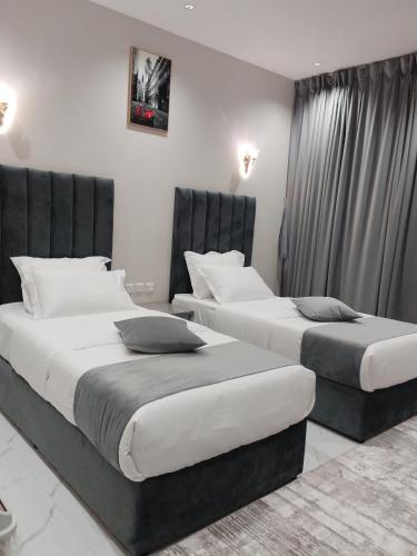 two beds in a hotel room withskirts at العلي للشقق المخدومة Alalihotel in Hafr Al Baten