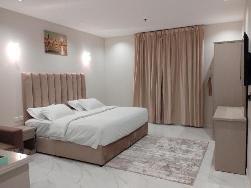 a bedroom with a large bed and a window at العلي للشقق المخدومة Alalihotel in Hafr Al Baten