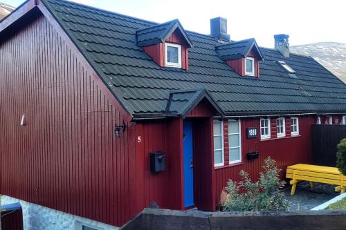 a red house with a black roof at Cozy cottage in Klaksvík
