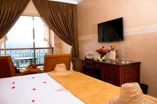 a hotel room with a table and a television at Borj Des Cascades & Spa in Ouzoud